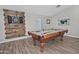 A well-lit game room features a pool table, a dart board and stylish artwork on the walls at 3812 W Carlos Ln, San Tan Valley, AZ 85144