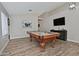 A game room is showcased with a pool table and a television over a dark console table at 3812 W Carlos Ln, San Tan Valley, AZ 85144