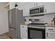 Modern kitchen featuring stainless steel appliances, granite countertops, and white cabinets for a sleek design at 3812 W Carlos Ln, San Tan Valley, AZ 85144