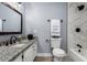 Well-lit bathroom featuring a granite vanity, tiled shower, and modern fixtures at 4028 W El Camino Dr, Phoenix, AZ 85051