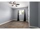 Bedroom with neutral carpet, window with curtains, and ceiling fan with light fixture at 4028 W El Camino Dr, Phoenix, AZ 85051
