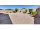 Large backyard with gravel, lush green bushes, and a brick-paved patio area at 4218 W Palace Station Rd, New River, AZ 85087
