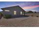 Large backyard with gravel, lush green bushes, and a brick-paved patio area during sunset at 4218 W Palace Station Rd, New River, AZ 85087