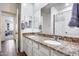 Bathroom featuring double sinks with granite counters, wood-look tile flooring, and a walk-in shower at 4218 W Palace Station Rd, New River, AZ 85087