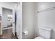 Bright bathroom with a toilet, shower with curtain, and a glimpse of a laundry area through an open door at 4218 W Palace Station Rd, New River, AZ 85087