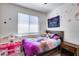 Charming bedroom with a wooden bed frame, a window with blinds, and playful wall decorations at 4218 W Palace Station Rd, New River, AZ 85087