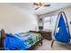 Bright bedroom featuring a ceiling fan, a dresser, and a cozy hanging chair near the window at 4218 W Palace Station Rd, New River, AZ 85087