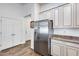 Open-concept kitchen features stainless steel refrigerator, modern cabinets, and tile flooring at 4218 W Palace Station Rd, New River, AZ 85087
