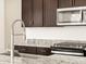 Close up of a stainless steel faucet, granite countertop, stainless steel microwave and gas range in the kitchen at 4256 W Lisa Ln, San Tan Valley, AZ 85144