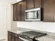Stainless steel microwave and gas range sit on top of granite countertop in kitchen at 4256 W Lisa Ln, San Tan Valley, AZ 85144