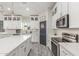 Bright kitchen with modern white cabinetry, a large island, stainless steel appliances, and sleek countertops at 4446 W Kimberly Way, Glendale, AZ 85308