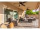 Relaxing covered patio complete with ceiling fans, comfortable seating, and a cozy backyard at 4446 W Kimberly Way, Glendale, AZ 85308