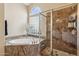Elegant bathroom featuring a soaking tub, glass block window, and a glass-enclosed shower at 4515 E Casey Ln, Cave Creek, AZ 85331