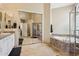 Bathroom featuring a bathtub, glass shower, double sinks, granite countertops, and large vanity mirror at 4515 E Casey Ln, Cave Creek, AZ 85331