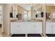 Bathroom with double sinks, white cabinets, granite counters, and a large, well-lit mirror at 4515 E Casey Ln, Cave Creek, AZ 85331