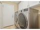 Bright laundry room featuring side-by-side stainless steel washer and dryer units and ample cabinet space at 4515 E Casey Ln, Cave Creek, AZ 85331