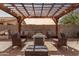 Outdoor patio with pergola with chairs, a fire pit, and block wall fencing at 45574 W Tulip Ln, Maricopa, AZ 85139