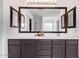 Bathroom vanity with a large framed mirror, bright lighting, and ample drawer storage at 45574 W Tulip Ln, Maricopa, AZ 85139