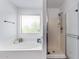 Bright bathroom featuring a garden tub, glass-enclosed shower, and natural light at 45574 W Tulip Ln, Maricopa, AZ 85139