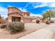 Two-story home features a two-car garage, a cozy front porch and colorful flowering bushes at 45574 W Tulip Ln, Maricopa, AZ 85139