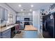 Charming kitchen with blue cabinets, butcher block island, black appliances, and plenty of storage at 45574 W Tulip Ln, Maricopa, AZ 85139