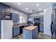 Charming kitchen with blue cabinets, butcher block island, black appliances, and plentiful counter space at 45574 W Tulip Ln, Maricopa, AZ 85139