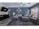 Cozy living room with gray sofa, ceiling fan, decorative wall art and entertainment center at 45574 W Tulip Ln, Maricopa, AZ 85139