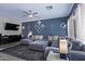 Bright living room with large sectional sofa, stylish decor, and hardwood floors at 45574 W Tulip Ln, Maricopa, AZ 85139