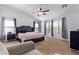 Bright and airy main bedroom featuring a king bed, ceiling fan, and large windows with views at 45574 W Tulip Ln, Maricopa, AZ 85139