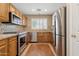 Well lit kitchen with wood cabinets, tile backsplash, granite countertops, and stainless steel appliances at 4718 E Woburn Ln, Cave Creek, AZ 85331