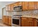 Well-equipped kitchen with stainless steel appliances, granite counters, and mosaic backsplash at 4718 E Woburn Ln, Cave Creek, AZ 85331
