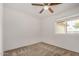 Simple bedroom with neutral carpet, ceiling fan, and window providing natural light at 5101 E Toniko Dr, Phoenix, AZ 85044