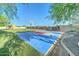 Outdoor basketball court is surrounded by lush landscaping and green grass at 6519 E Cactus Rd, Scottsdale, AZ 85254