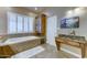 Bathroom showcasing vanity, plantation shutters, soaking tub and tile flooring at 6519 E Cactus Rd, Scottsdale, AZ 85254