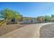 Inviting desert home with a circular driveway, desert landscaping, and a covered entry at 6519 E Cactus Rd, Scottsdale, AZ 85254