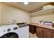 Neat laundry room featuring a washer, dryer, counter space, and tile flooring at 6519 E Cactus Rd, Scottsdale, AZ 85254