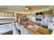 Open concept living room connecting to kitchen and dining area with stone fireplace and hardwood floors at 6519 E Cactus Rd, Scottsdale, AZ 85254
