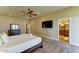 The main bedroom features a ceiling fan, carpet, TV, and entry into the main bathroom at 6519 E Cactus Rd, Scottsdale, AZ 85254