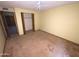 Bedroom featuring yellow walls, tan carpet, ceiling fan, closet, and attached bathroom at 664 N Glenview --, Mesa, AZ 85213