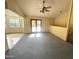 Spacious living area with ceiling fan, glass doors to a sunroom, carpet, and tiled kitchen at 664 N Glenview --, Mesa, AZ 85213