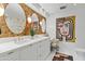 The vanity in this bathroom has double sinks, oval mirrors, and decorative floral accents at 7167 E Rancho Vista Dr # 5001, Scottsdale, AZ 85251