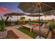 Inviting patio featuring a cozy seating area with an outdoor kitchen, fire pit, and shade umbrellas at dusk at 7167 E Rancho Vista Dr # 5001, Scottsdale, AZ 85251