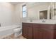 Modern bathroom featuring double sinks, dark wood cabinets and bathtub with white tile at 7229 E Cattle Call St, San Tan Valley, AZ 85143