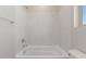 Bright bathroom featuring a bathtub and white marble patterned tiles at 7229 E Cattle Call St, San Tan Valley, AZ 85143