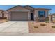 Charming home featuring a gray stucco exterior, blue shutters, desert landscaping and a large two car garage at 7229 E Cattle Call St, San Tan Valley, AZ 85143