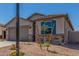 Charming home featuring a gray stucco exterior, blue shutters, desert landscaping and a large two car garage at 7229 E Cattle Call St, San Tan Valley, AZ 85143