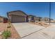 Charming home featuring a gray stucco exterior, blue shutters, desert landscaping and a large two car garage at 7229 E Cattle Call St, San Tan Valley, AZ 85143