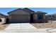 Charming single-story home with a stone-accented facade, a two-car garage and a well-kept desert landscape at 7229 E Cattle Call St, San Tan Valley, AZ 85143