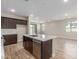 Modern kitchen featuring dark wood cabinets, quartz countertops and stainless steel appliances and wood tile flooring at 7229 E Cattle Call St, San Tan Valley, AZ 85143