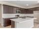 Modern kitchen featuring dark wood cabinets, white subway tile backsplash, quartz countertops and stainless steel appliances at 7229 E Cattle Call St, San Tan Valley, AZ 85143